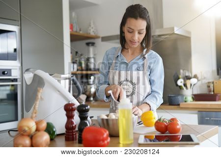 Woman using kitchen robot to prepare dinner