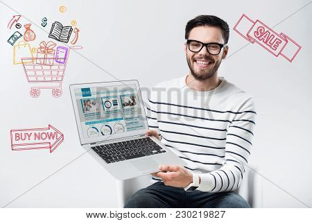 Cheep Device. Emotional Young Clever Man Feeling Happy And Holding A New Wonderful Laptop After Buyi
