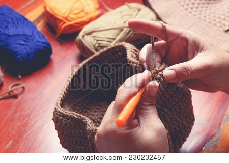 Close Up Hand Of Old Woman Knitting Woolhate On Wooden Table Background