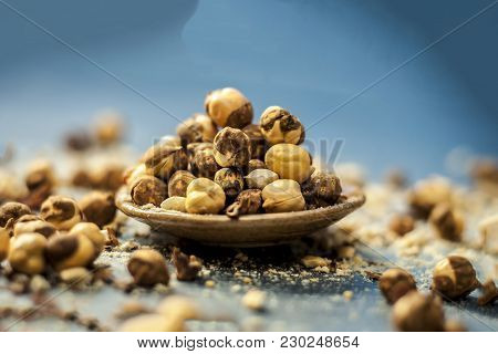 Close Up Of Baked Or Roasted Chickpea/channa Or Dalia In A Bowl On A Blue Surface.