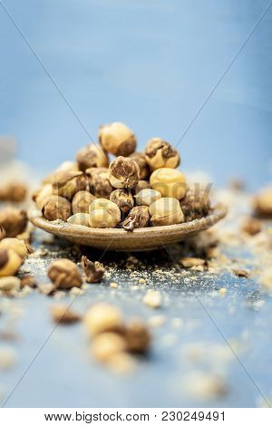 Close Up Of Baked Or Roasted Chickpea/channa Or Dalia In A Bowl On A Blue Surface.