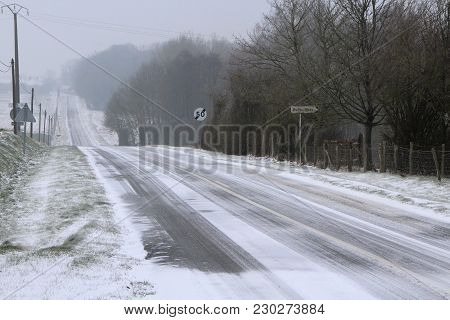 A Small Contry Road Covered By Snow