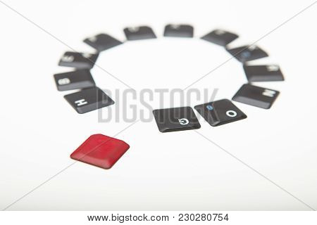 Circle Of Loose Alphanumeric Computer Keyboard Key Covers With One Single Red One In The Foreground 