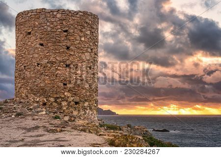 Sunrays Bursting Onto The Mediterranean Sea As The Sun Sets Behind The Ancient Genoese Tower At Punt