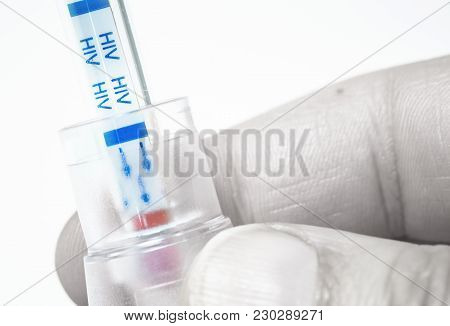 A Hand Holding An Hiv Self-test With Blood Inside On Desaturate Effect