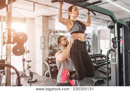 Trainer And His Student Is In The Gy. He Is Helping Her To Pull Up. This Is A Part Of Big List Of Ex