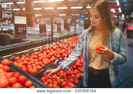 Beautiful And Awesome Lady Is At Grossary Store And Choosing Some Tomatoes To Buy. She Has Chosen On