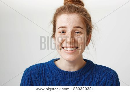 Close-up Portrait Of Good-looking Girl With Freckles And Natural Red Hair Smiling Nervously And Chuc