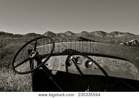 Dash And Steering Wheeling Is All Which Is Left Of An Old Truck In The Desert. (black And White)