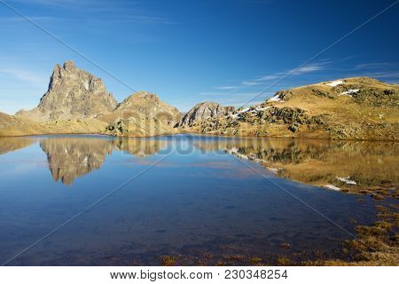 Midi Dossau Peak reflected in a lake. Ossau Valley, Pyrenees National Park, Pyrenees, France.