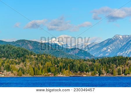 Fantastic view over ocean, snow mountain and rocks at Sechelt inlet in Vancouver, Canada.
