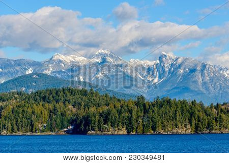 Fantastic view over ocean, snow mountain and rocks at Sechelt inlet in Vancouver, Canada.