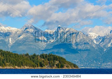 Fantastic view over ocean, snow mountain and rocks at Sechelt inlet in Vancouver, Canada.
