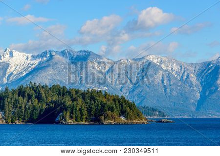 Fantastic view over ocean, snow mountain and rocks at Sechelt inlet in Vancouver, Canada.