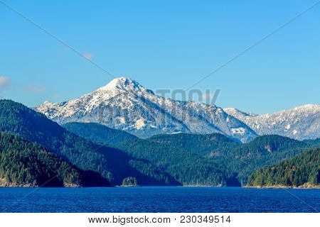 Fantastic view over ocean, snow mountain and rocks at Sechelt inlet in Vancouver, Canada.