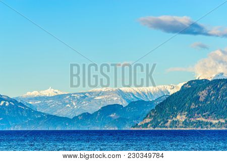 Fantastic view over ocean, snow mountain and rocks at Sechelt inlet in Vancouver, Canada.