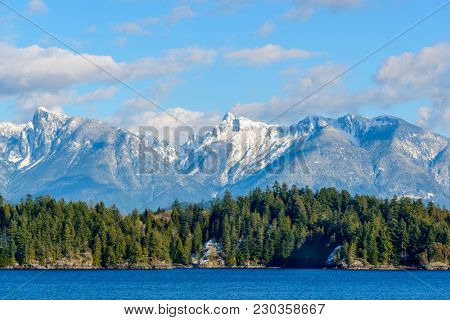 Fantastic view over ocean, snow mountain and rocks at Sechelt inlet in Vancouver, Canada.
