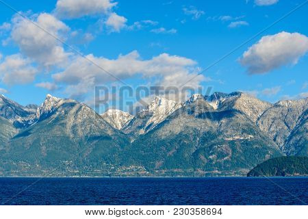 Fantastic view over ocean, snow mountain and rocks at Sechelt inlet in Vancouver, Canada.