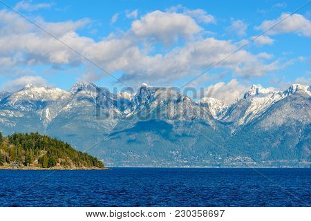 Fantastic view over ocean, snow mountain and rocks at Sechelt inlet in Vancouver, Canada.