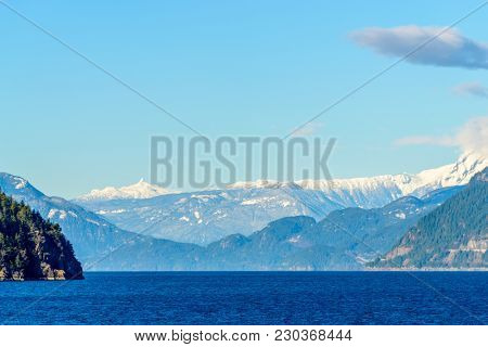Fantastic view over ocean, snow mountain and rocks at Sechelt inlet in Vancouver, Canada.