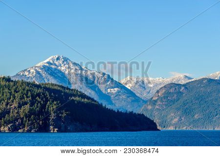 Fantastic view over ocean, snow mountain and rocks at Sechelt inlet in Vancouver, Canada.