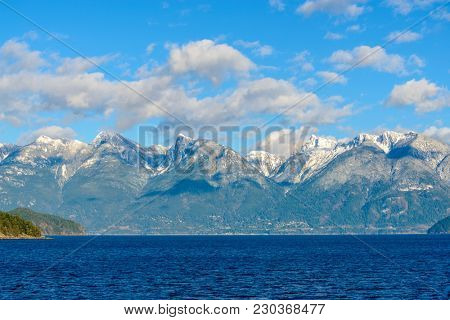 Fantastic view over ocean, snow mountain and rocks at Sechelt inlet in Vancouver, Canada.