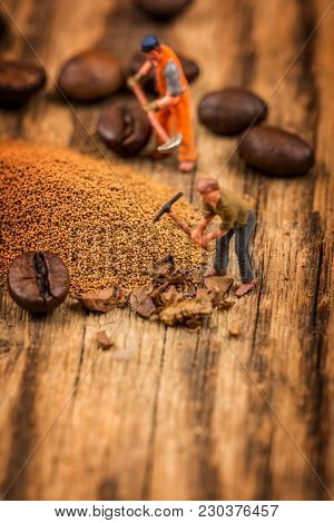 Miniature Figures Working On Instant Coffee Macro Photography On Wood Table