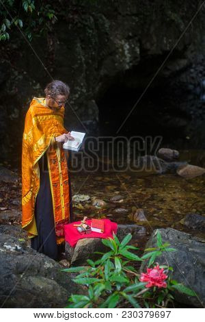 KOH CHANG, THAILAND - MAR 9, 2018: Orthodox priest during sacrament of spiritual birth - Baptism. There are currently 10 Orthodox parishes in Thailand, Orthodoxy is practiced by 0.002% of population.
