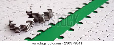 The Green Path Is Laid On The Platform Of A White Folded Jigsaw Puzzle. The Missing Elements Of The 