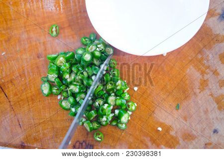Green Sliced Peppers On A Wooden Cutting Board