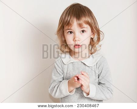 Portrait Of Little Baby Girl With Serious Face, Look Forward.