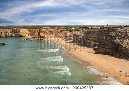 SAGRES, PORTUGAL - AUGUST 25, 2016: Aerial view of surfers on sandy beach near Sagres village in Portugal
