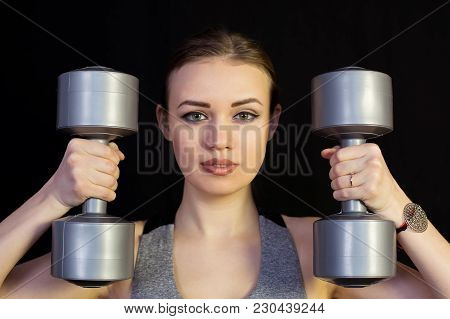 The Athlete Is Engaged With Heavy Dumbbells On A Black Background.