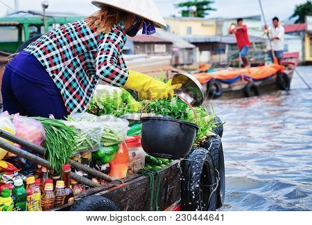 Can Tho, Vietnam - February 28, 2016: Woman In A Boat Selling Fresh Green Vegetables At The Floating