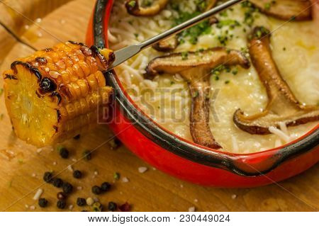 Roasted Maize In Smelted Goat Cheese With Shiitake Mushrooms Closeup In Red Clay Pot.