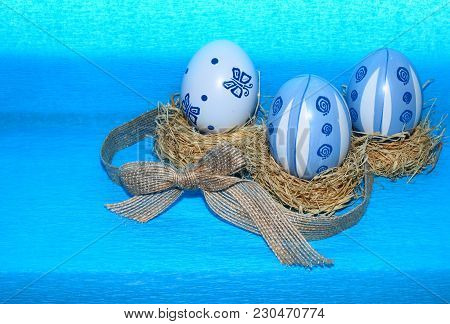 Easter Eggs,straw And Bow-knot On A Blue Background