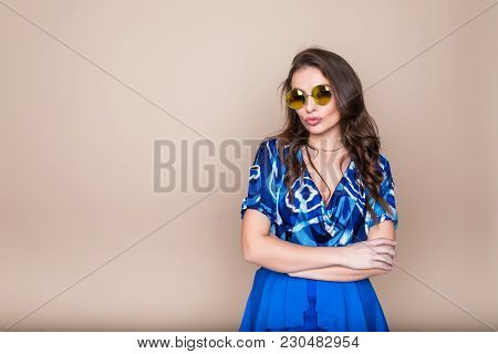 Smiling Woman With Crossed Arms Portrait On Colow Studio Background
