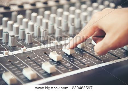 Hands Of Sound Engineer Working On Recording Studio Mixer. Expert Adjusting The Volume Of A Voice, M