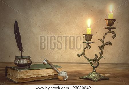 Old Book And Feather Pen With Inkpot And Rusty Key On Retro Wooden Table Background In The Light Of 