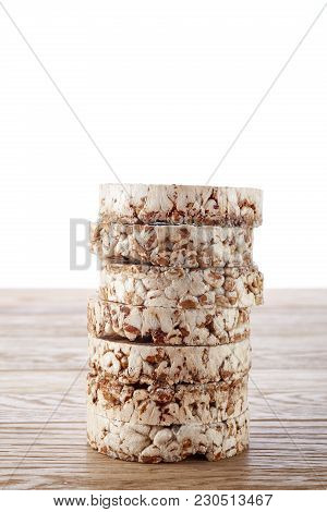 Stack Of Diet Crispbreads On Light Wooden Table, Close-up, Selective Focus. Composition Of Puffed Ri