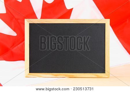 Blackboard With The National Flag Of Canada Drawn On And A Chalk