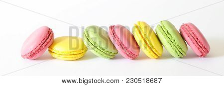 Row Of Three Different Types Of Macaroons Colors Pink, Green And Yellow Isolated On White Background
