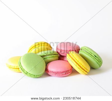 Three Different Types Of Macaroons Colors Pink, Green And Yellow Isolated On White Background. Close