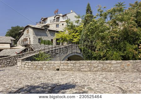 Mostar, Bosnia And Herzegovina - August17 2017: Kriva Cuprija Ancient Bridge In Mostar, Surrounded B