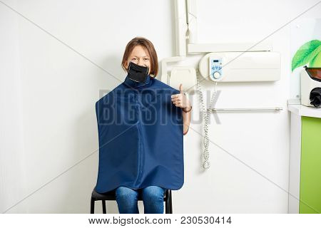 Patient Of A Dental Office With A Kofferdam Is Prepared For An X-ray And Is Smiling To The Camera Wh