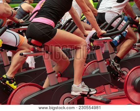Group Of Boys And Girls At Gym: Workout With Spinning Bikes.
