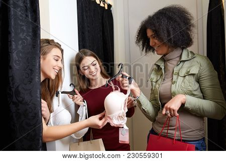Beautiful Young Woman Asking For A Friends Opinion In The Fitting Room Of Lingerie Store. Female Tri