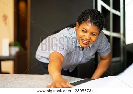 Maid Making Bed In Hotel Room. Maid Making Bed