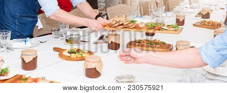 Waiter Serving Meat Dishes On Wooden Board At Restaurant, Close Up View