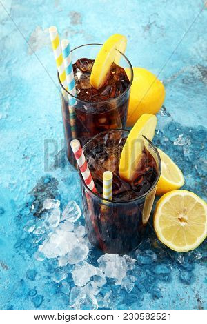 Softdrink With Ice Cubes, Lemon And Straw In Glass.